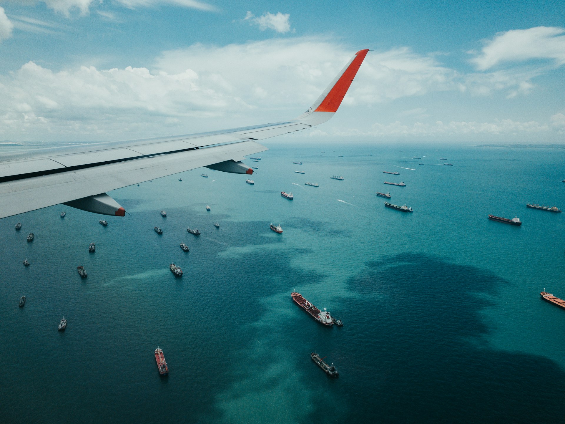 aile d'avion au-dessus de la mer pendant la journée